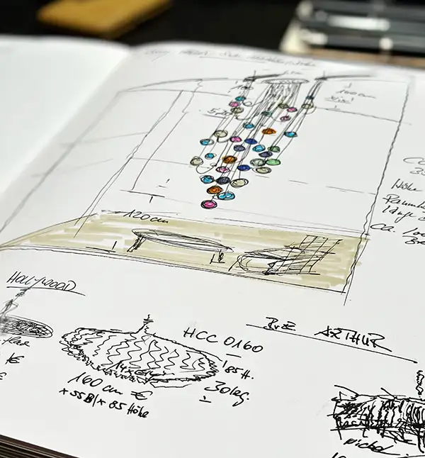 Ein aufgeschlagenes Skizzenbuch mit Entwurfs-Zeichnungen für mögliche Beleuchtungskonzepte